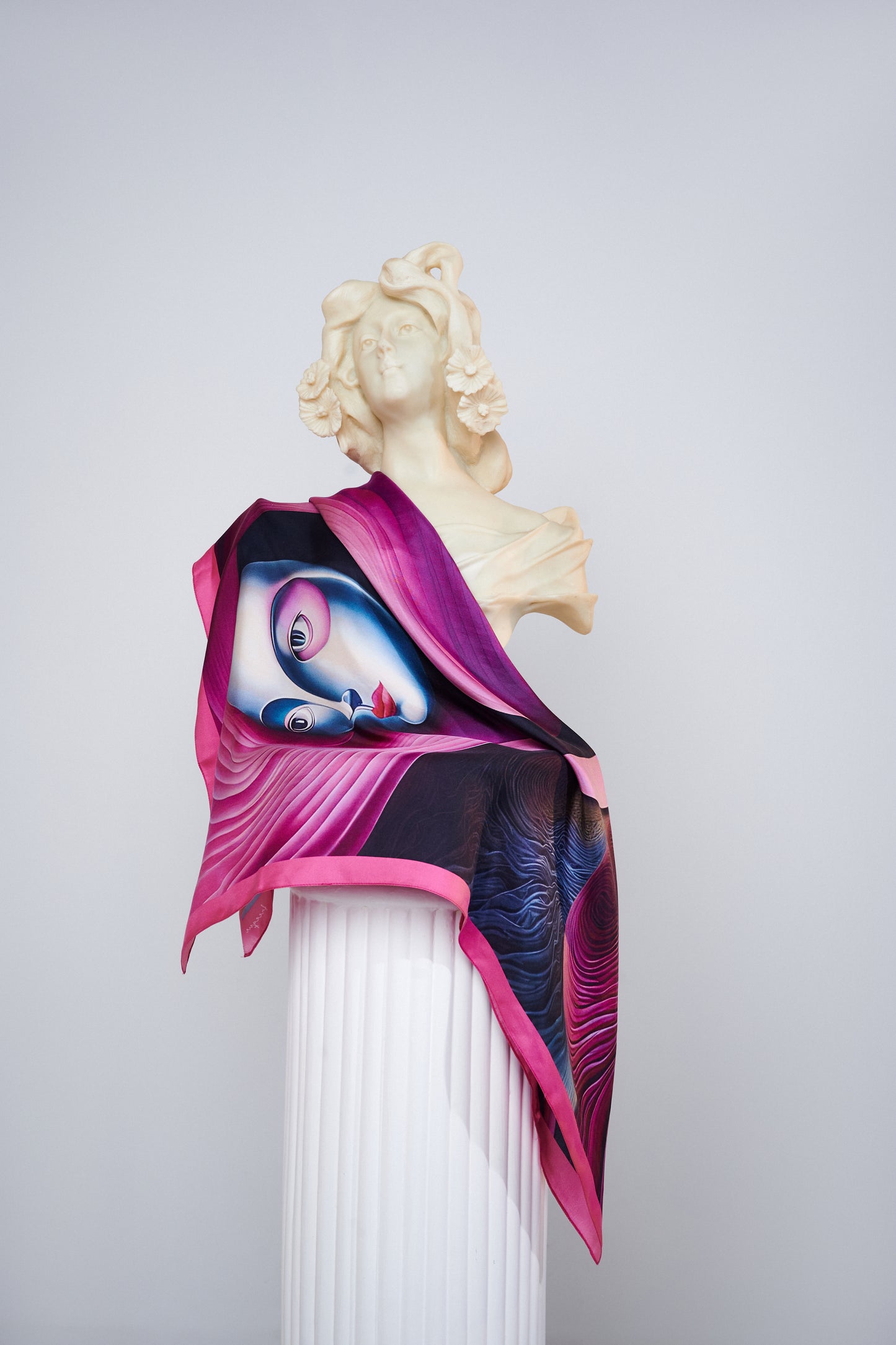 The "Elpída" scarf draped over a statue, emphasizing luxury and artistic expression.