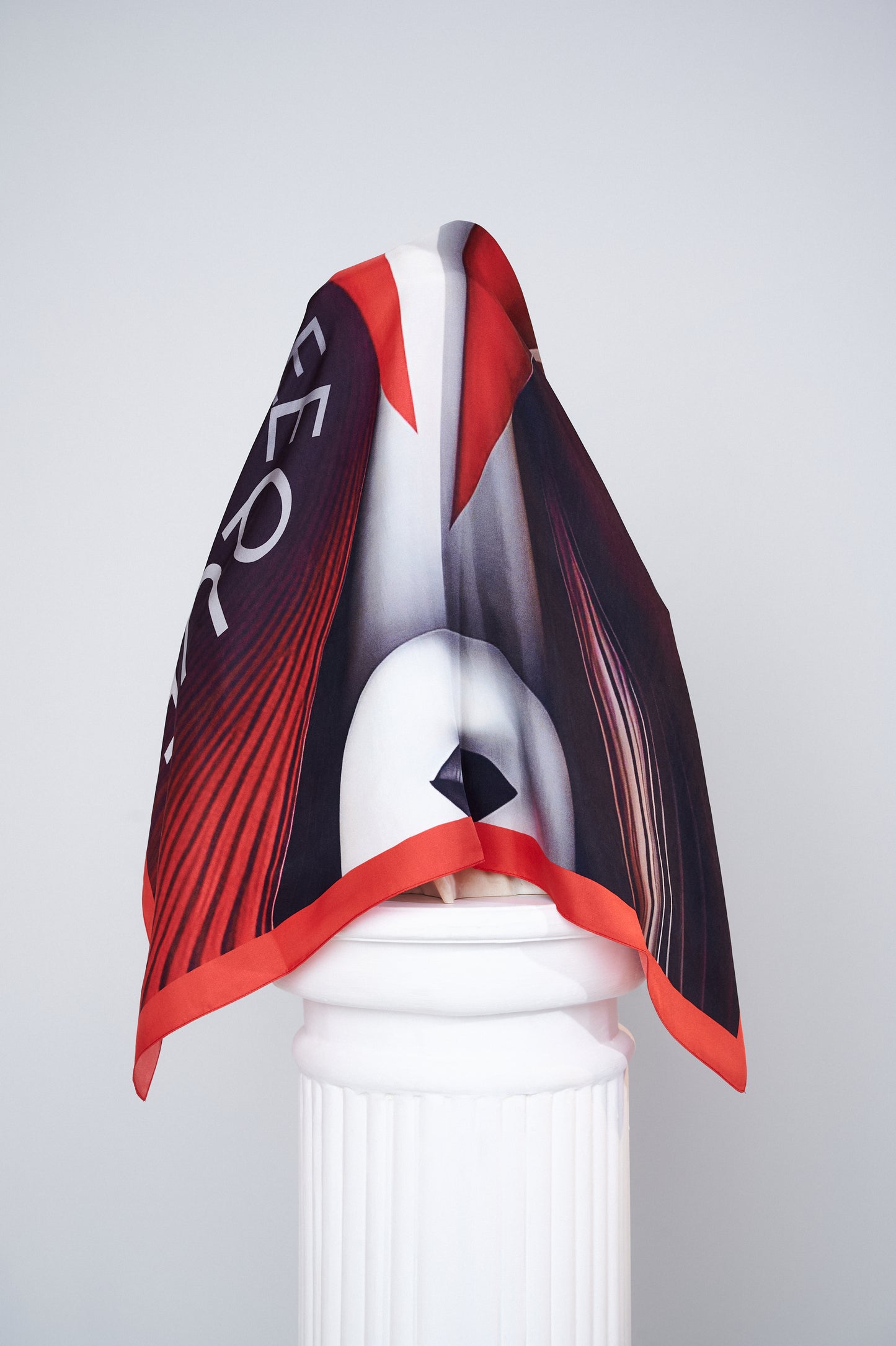 Ira scented scarf styled on a column, emphasizing the abstract face and expressive design.