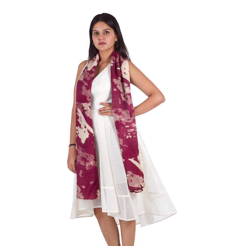 Woman in white dress wearing Freeque's Berry Grunge scented shawl in red and beige, styled elegantly over shoulders.