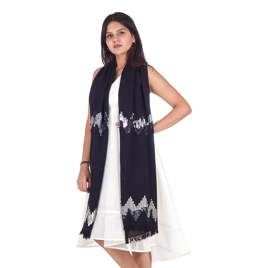 Model wearing Freeque's Lunar Eclipse fragrance-free shawl with color-changing silver and black sequins, styled elegantly over a white dress