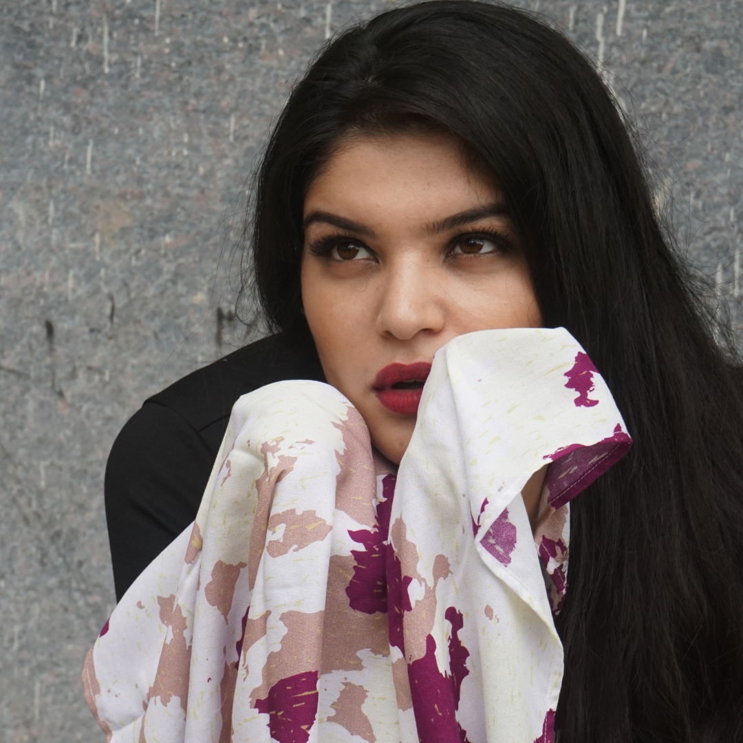 Close-up of model holding a luxurious Plum Veil scented stole with soft floral design.