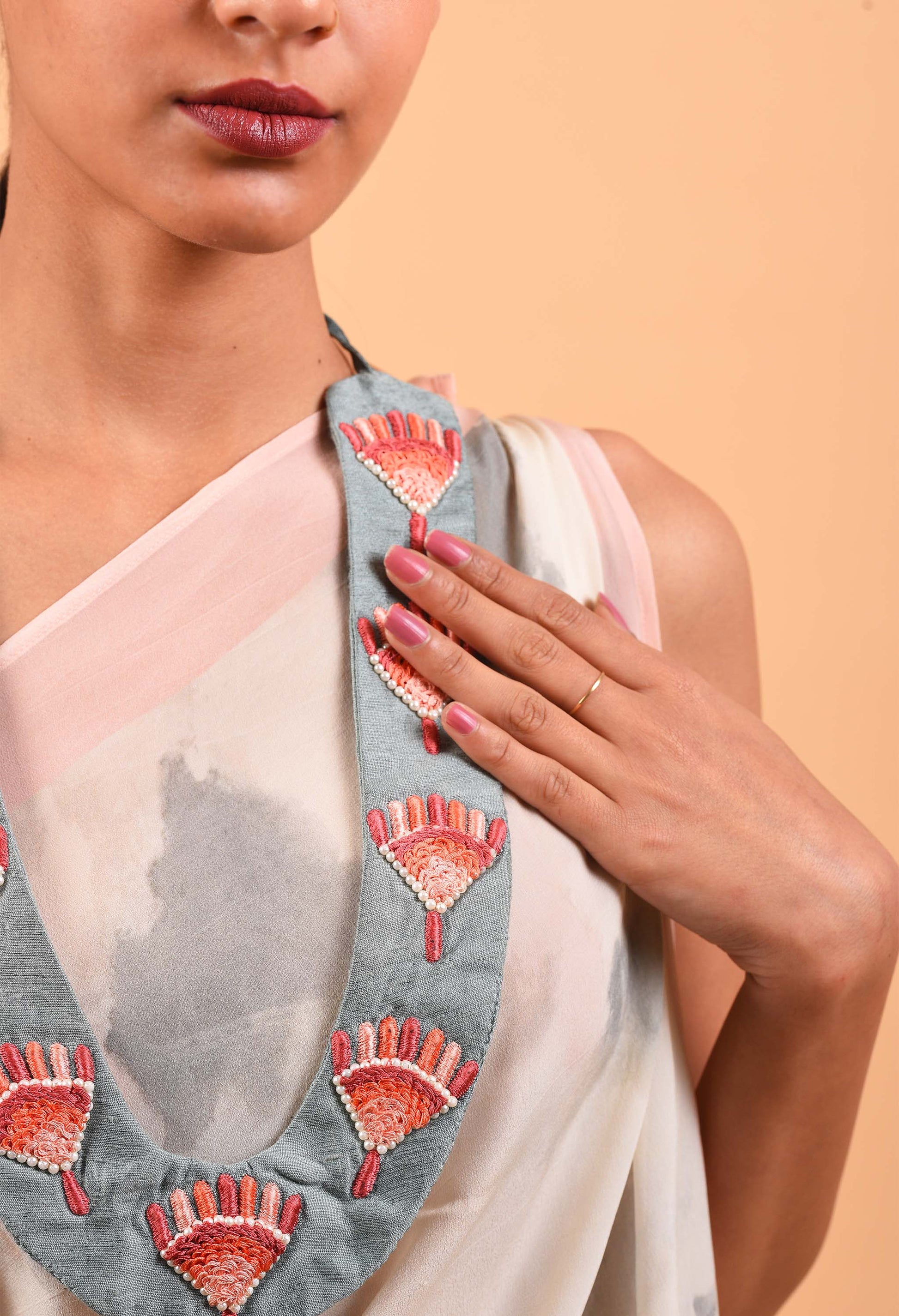 Model wearing Realm handcrafted necklace with intricate fan design detailing, close-up