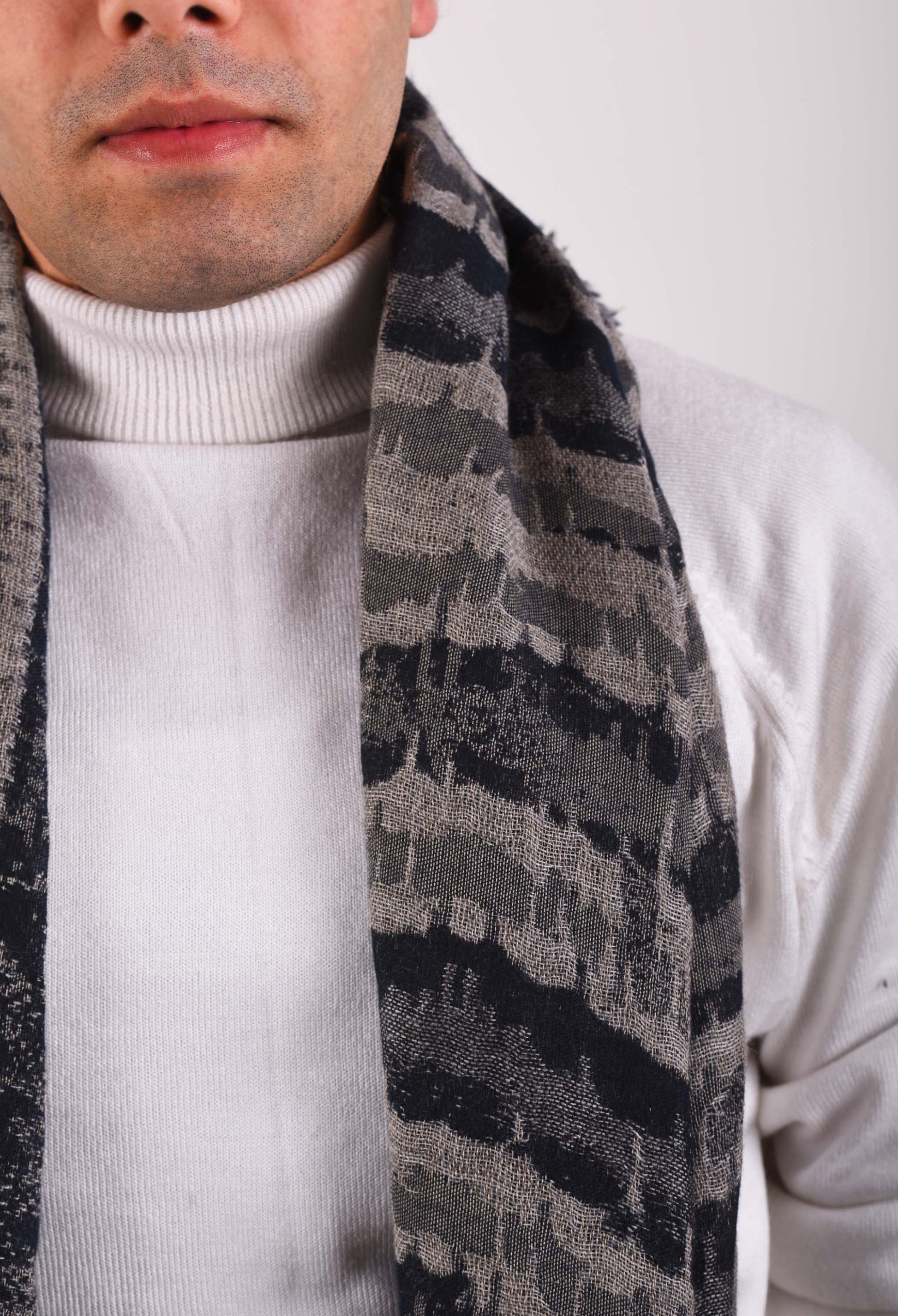 Close-up of Saige camel wool stole on a white turtleneck.