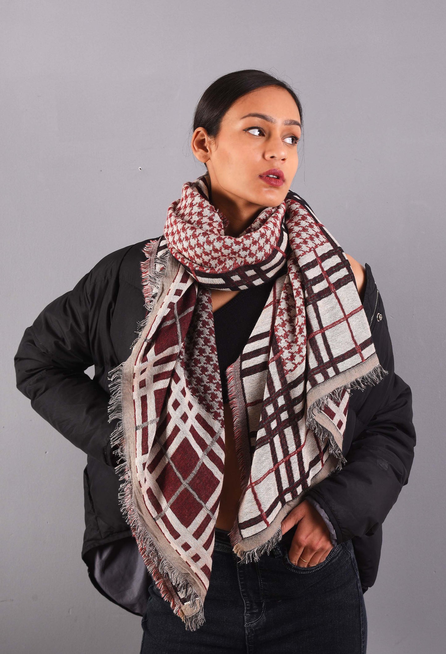 Model wearing Freeque's Zion camel wool stole with geometric patterns in red and black.